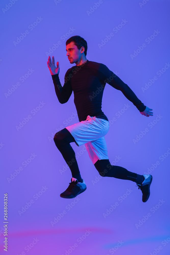 Full length portrait of a fit sportsman running isolated