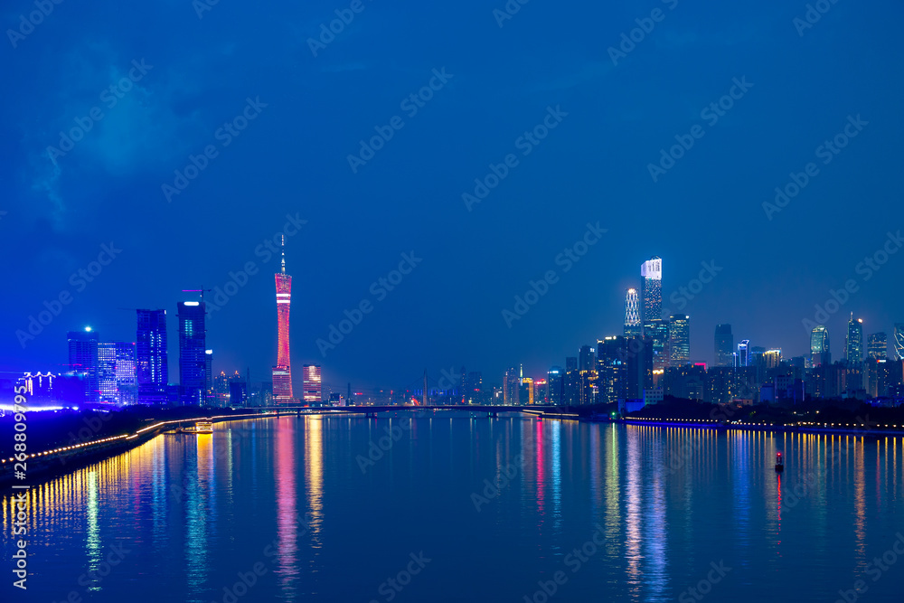 Guangzhou cityscape over the Pearl River with Liede Bridge, Canton TV Tower and financial district illuminated in the evening. Guangzhou, Southern China.