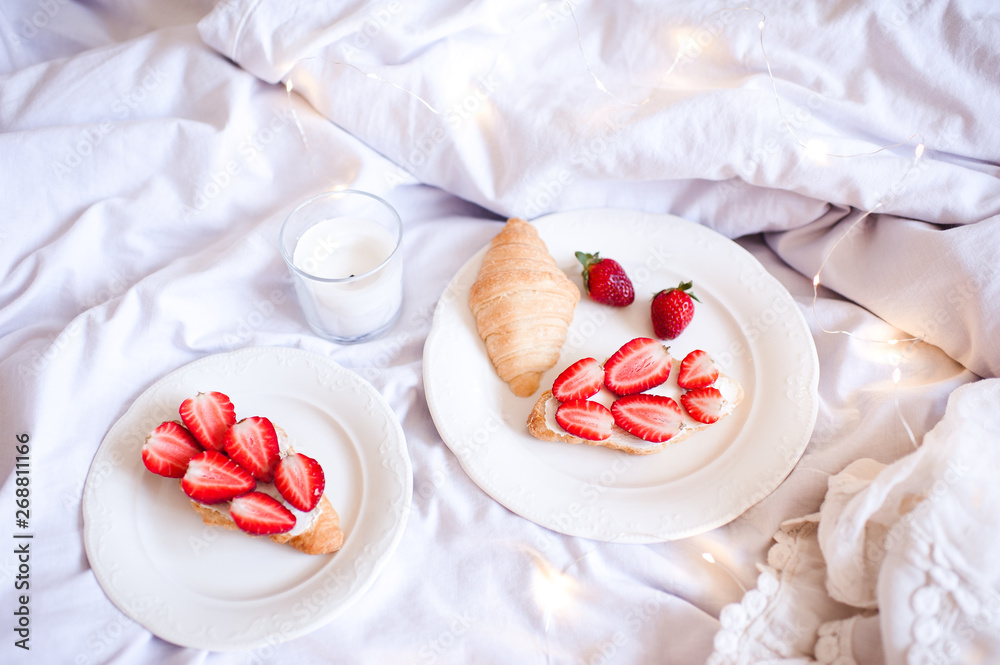 Tasty breakfast with fresh strawberry and cakes in bed closeup. Good morning. Tasty breakfast with fresh strawberry and cakes in bed closeup. Good morning.