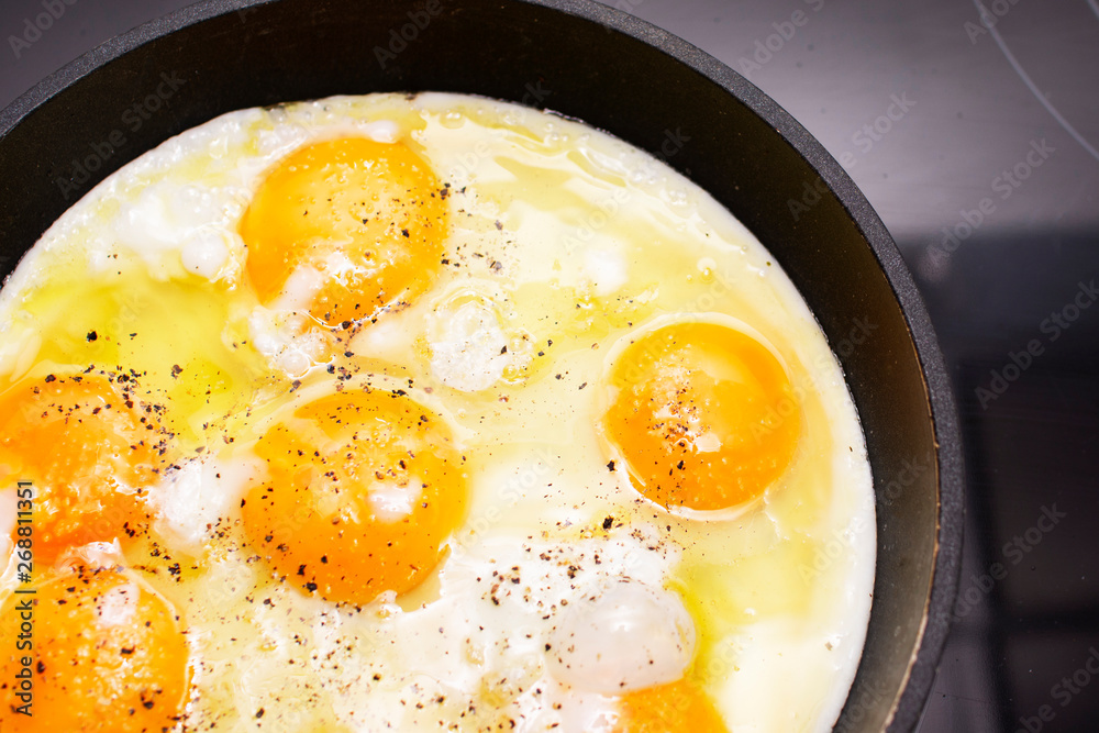 Fried eggs are cooked in a pan on the stove