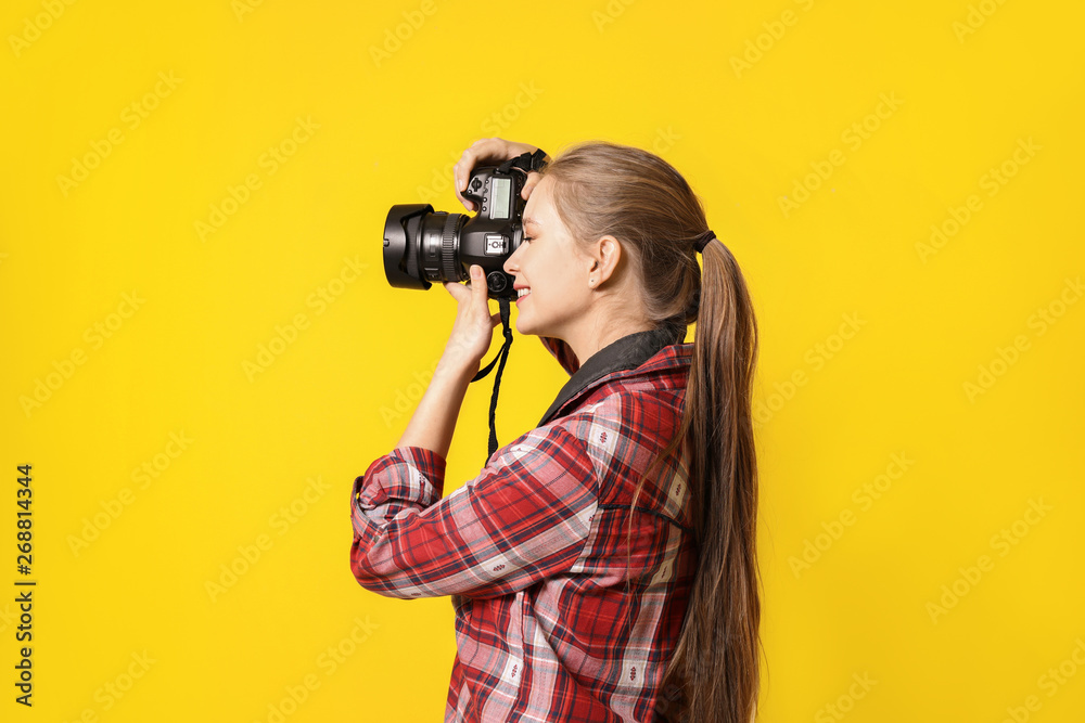 Young female photographer on color background Young female photographer on color background