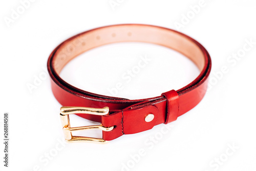 leather belt on a white background. The belt is twisted in a circle. gold hardware.