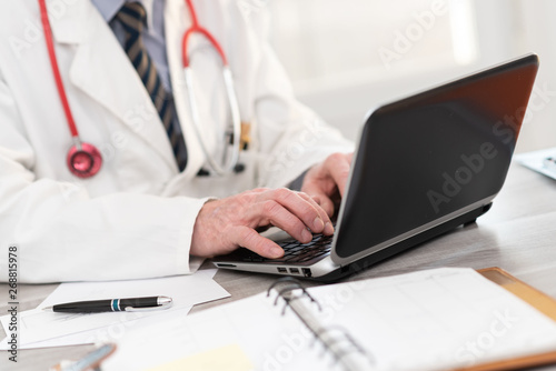Male doctor using laptop
