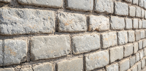 Stone wall. Stony blocks texture. Grey stone rock wall. Wall of gray stones bonded with cement. 