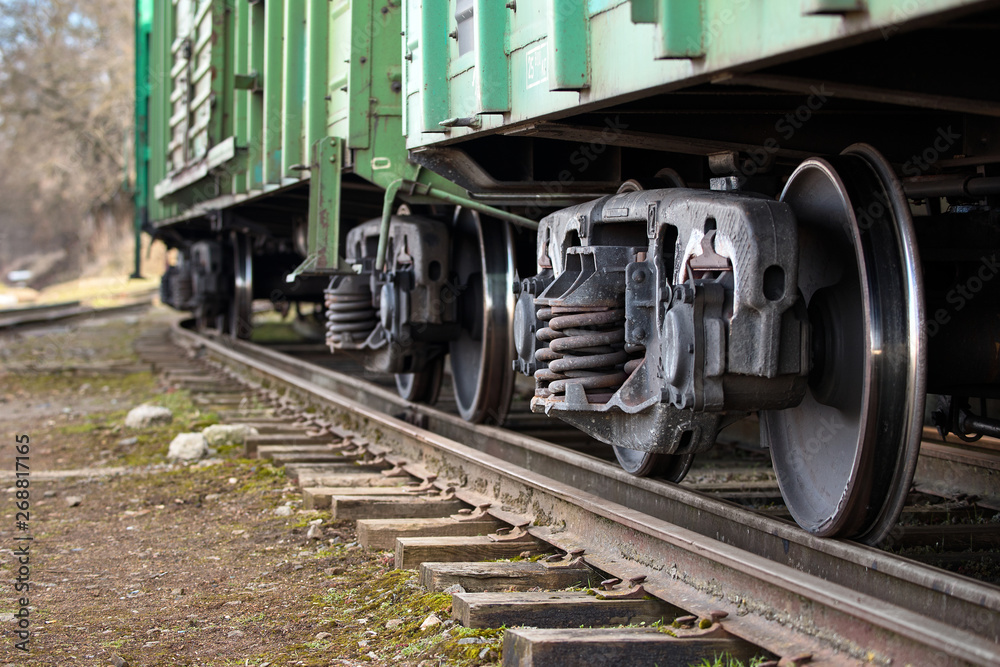 Dual gauge track example that allows the passage of trains of two different track gauges narrow-gauge railway and broad-gauge railway with freight wagons on it Dual gauge track example that allows the passage of trains of two different track gauges narrow-gauge railway and broad-gauge railway with freight wagons on it