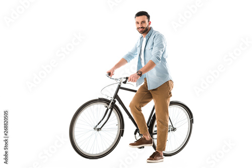 handsome cheerful man with bicycle smiling at camera isolated on white