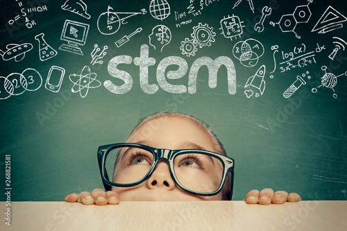 STEM word and doodles above beautiful cute little girl. modern education concept photo