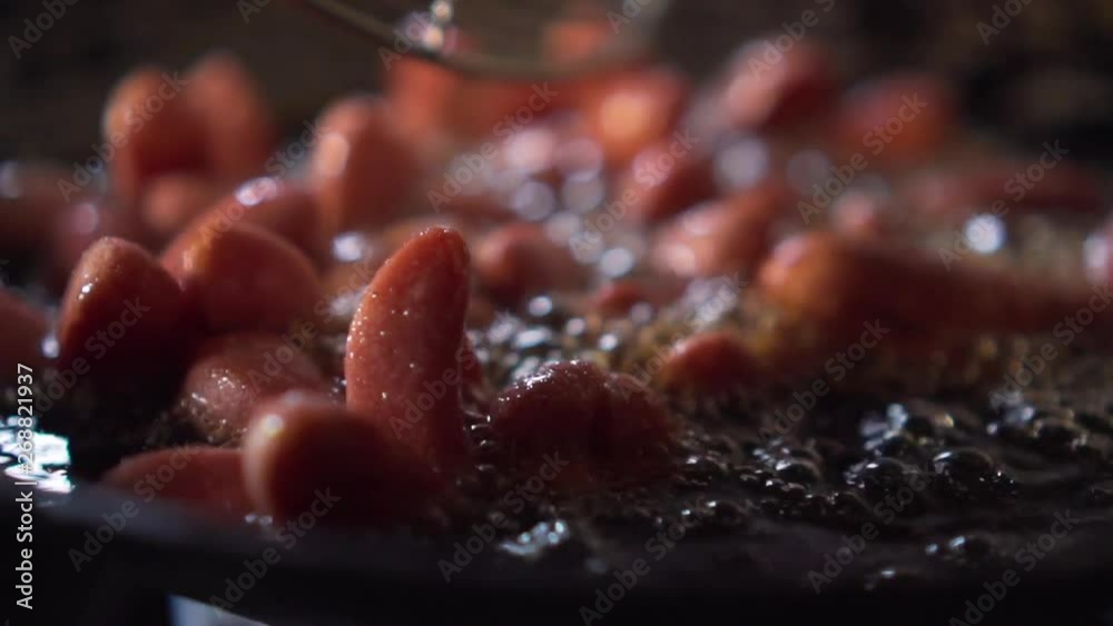 Slow motion of small sausage get fried on a pan full of oil. 1 Slow motion of small sausage get fried on a pan full of oil. 1