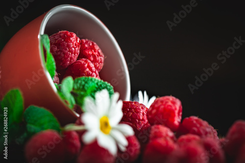 Raspberry. Raspberries in a Cup on a dark background. Summer and healthy food concept. Background with copy space. Selective focus.