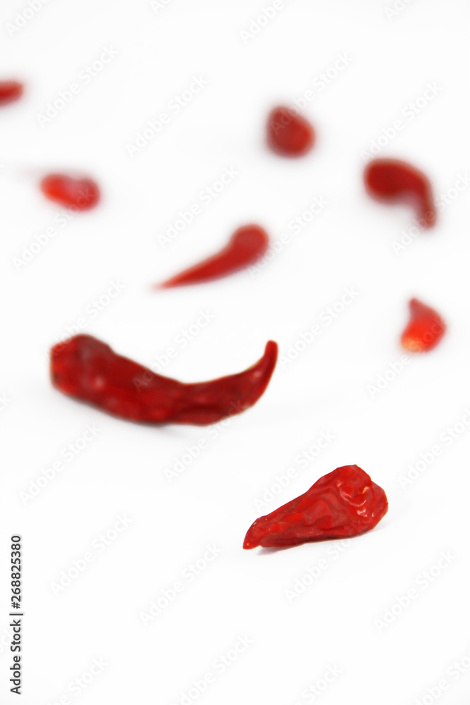 pods of red dried hot bitter edible pepper on a white background