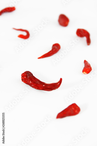 pods of red dried hot bitter edible pepper on a white background