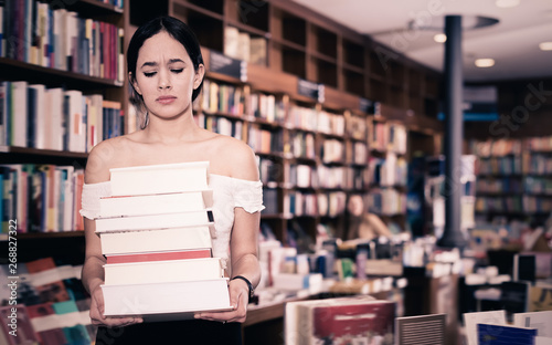 Young student standing with pile of books
