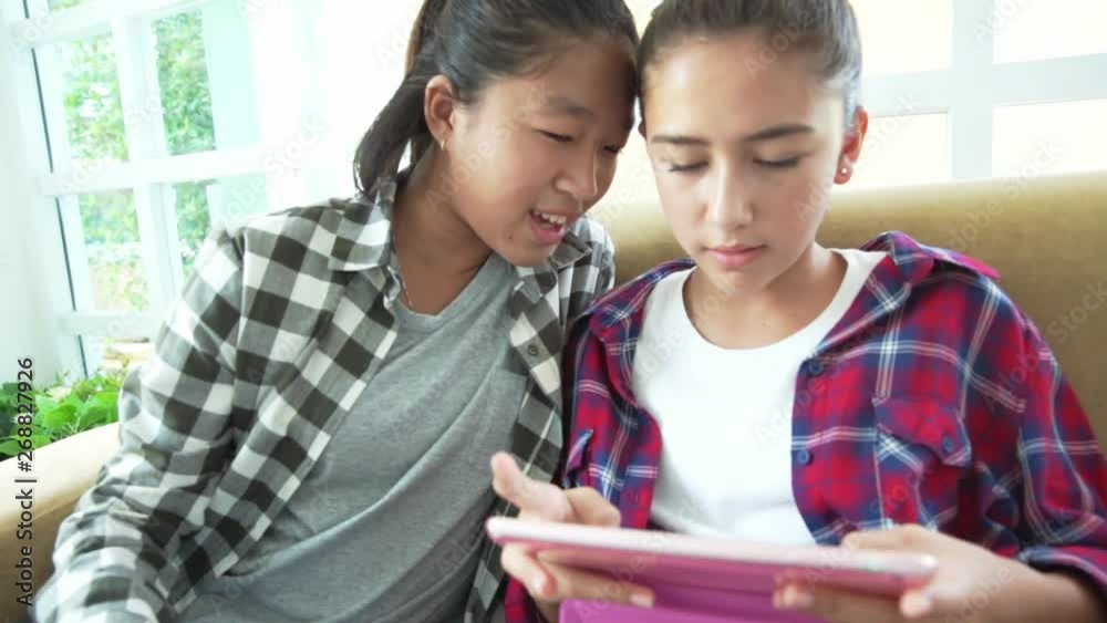Students girls friend sitting on sofa and enjoy playing tablet computer, Diverse ethnicities using smartphone slow motion Students girls friend sitting on sofa and enjoy playing tablet computer, Diverse ethnicities using smartphone slow motion
