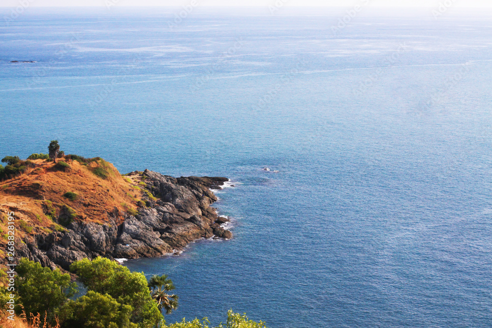 Fototapeta premium Beautiful seascape with sky twilight of sunset and sea horizon with Calm and blue sky.Dry grass field on mountain of Phrom Thep Cape is famous place in Phuket island, Thailand.