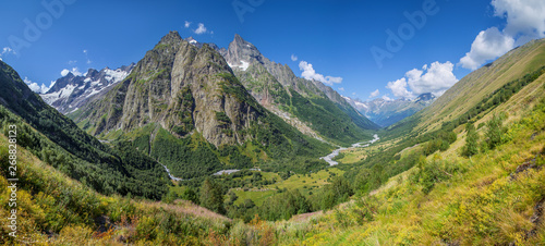 Scenic mountain valley in the Caucasus Mountains, summer greens and snow-capped peaks © Valerii