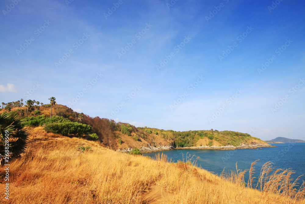 Beautiful seascape with sky twilight of sunset and sea horizon with Calm and blue sky.Dry grass field on mountain of Phrom Thep Cape is famous place in Phuket island, Thailand. Beautiful seascape with sky twilight of sunset and sea horizon with Calm and blue sky.Dry grass field on mountain of Phrom Thep Cape is famous place in Phuket island, Thailand.