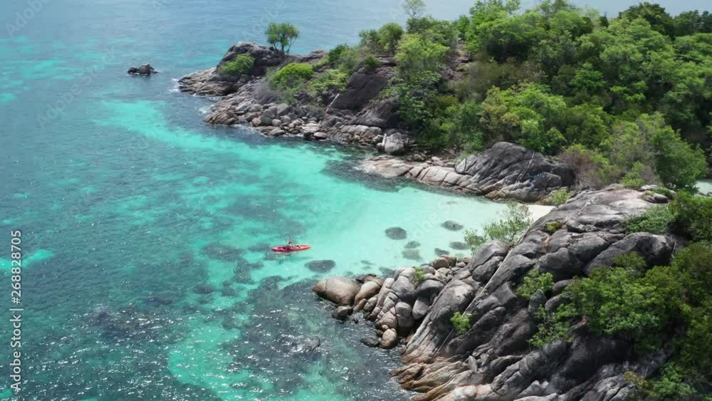 Aerial drone view of man kayaking in crystal clear lagoon sea water during summer day near Koh Kra island in Thailand. Travel tropical island holiday concept Aerial drone view of man kayaking in crystal clear lagoon sea water during summer day near Koh Kra island in Thailand. Travel tropical island holiday concept