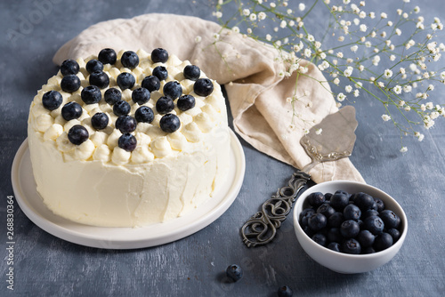 blueberry cake with cream cheese and fresh berrries on dark background. Copy space photo