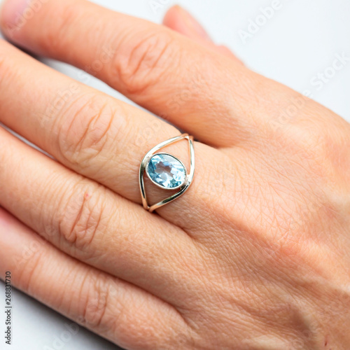 Silver ring with topaz gemstone caboshon on female hand