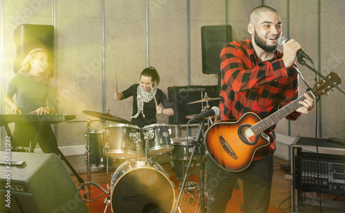 Bearded guy soloist playing guitar in studio photo