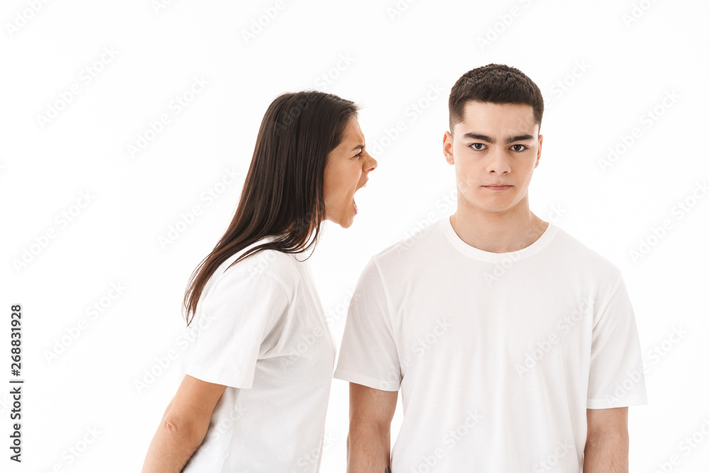 Angry young couple standing isolated over white background Angry young couple standing isolated over white background