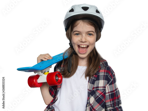 laughing positive girl in helmet holds skateboard in hands, concept of sport, active life, childhood