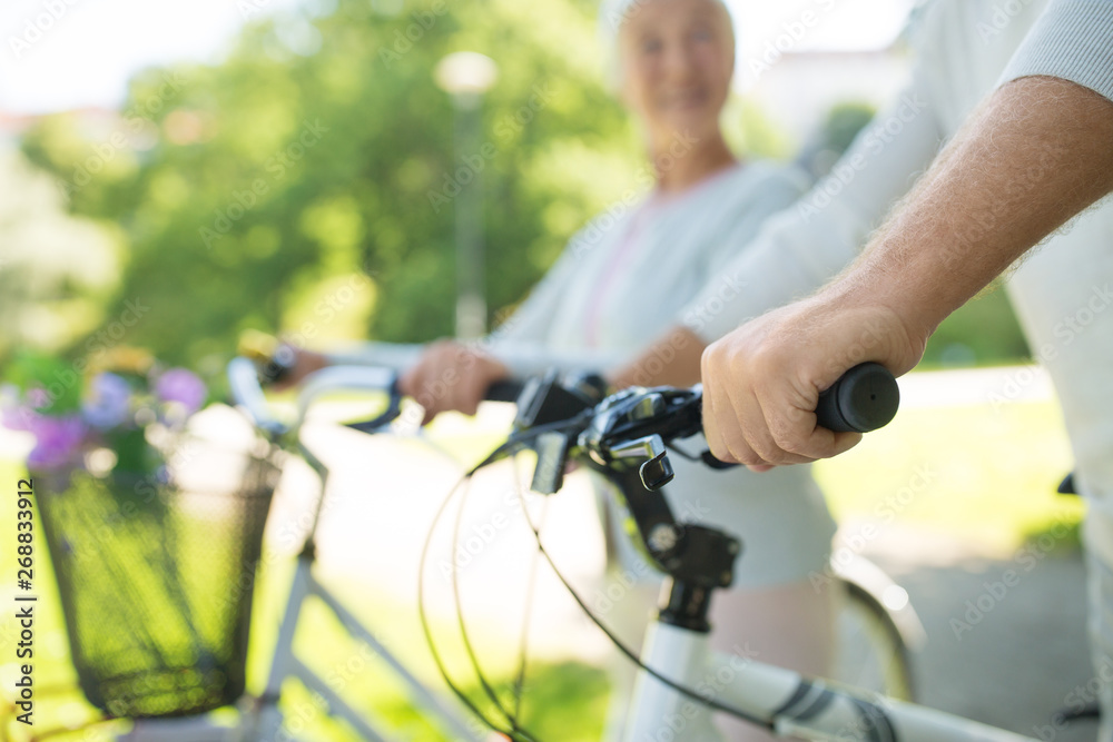 Obraz premium old age, people and lifestyle concept - close up of senior couple with bicycles at park in summer