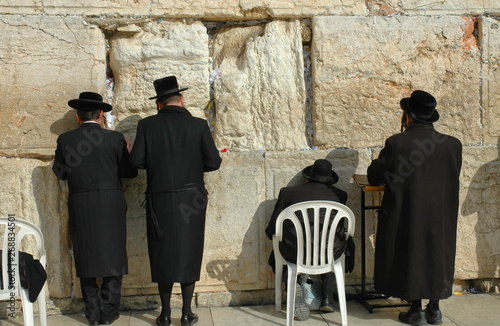 Three religious men at prayer at the wailing wall in Jerusalem
