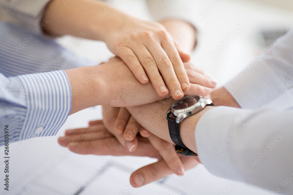 business, gesture and teamwork concept - close up of businesspeople stacking hands