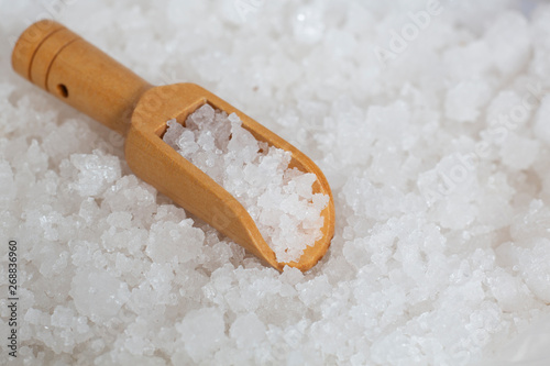 sea salt on wooden scoop spoon.