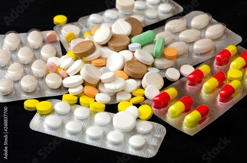 Color pills with blister on a dark background. Medicine and health. Vitamins.