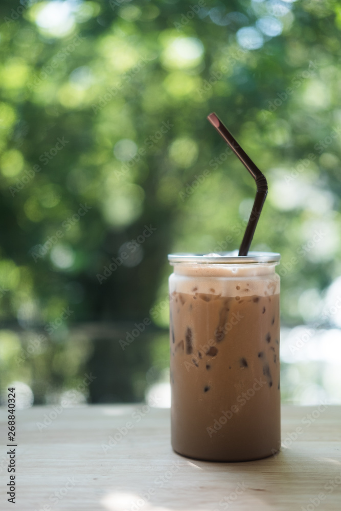Iced mocha in clear plastic bottles on wood table in coffee shop Iced mocha in clear plastic bottles on wood table in coffee shop