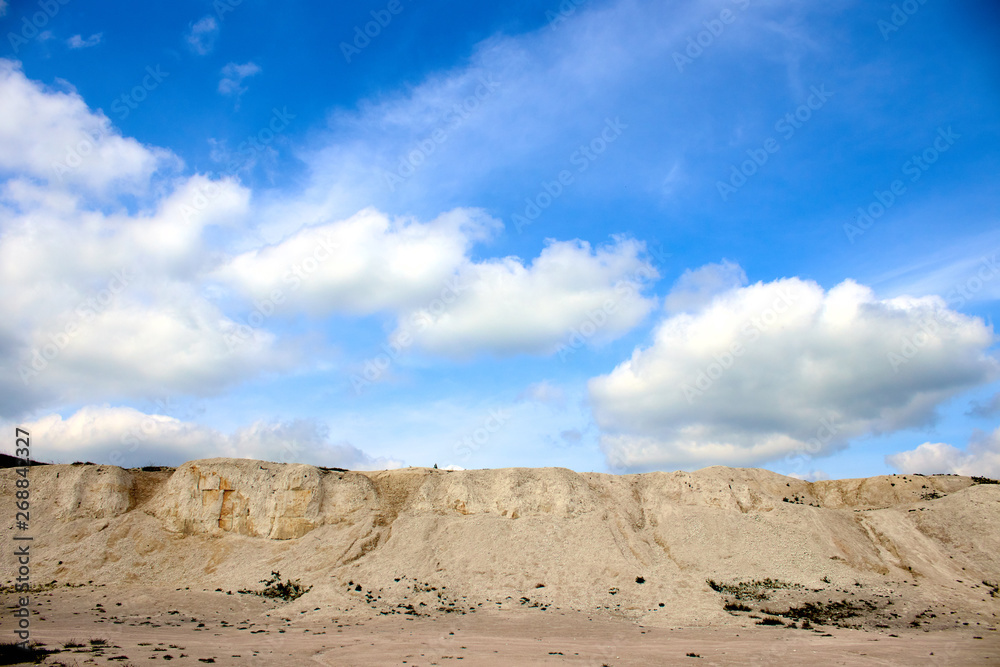 white limestone quarry on a background of blue sky with clouds white limestone quarry on a background of blue sky with clouds