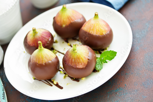 Dessert, fresh figs in chocolate with pistachios.