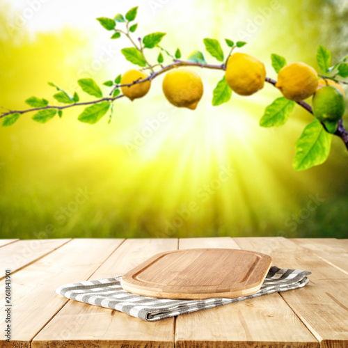 Table background of free space and summer garden background. Branch of fresh lemons and summser sunny day.  photo