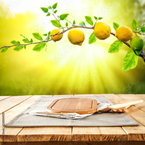 Table background of free space and summer garden background. Branch of fresh lemons and summser sunny day.  photo