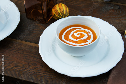 cream soup puree on the background of a decorative pumpkin in the garden on a wooden table   proper nutrition  diet  healthy lifestyle 