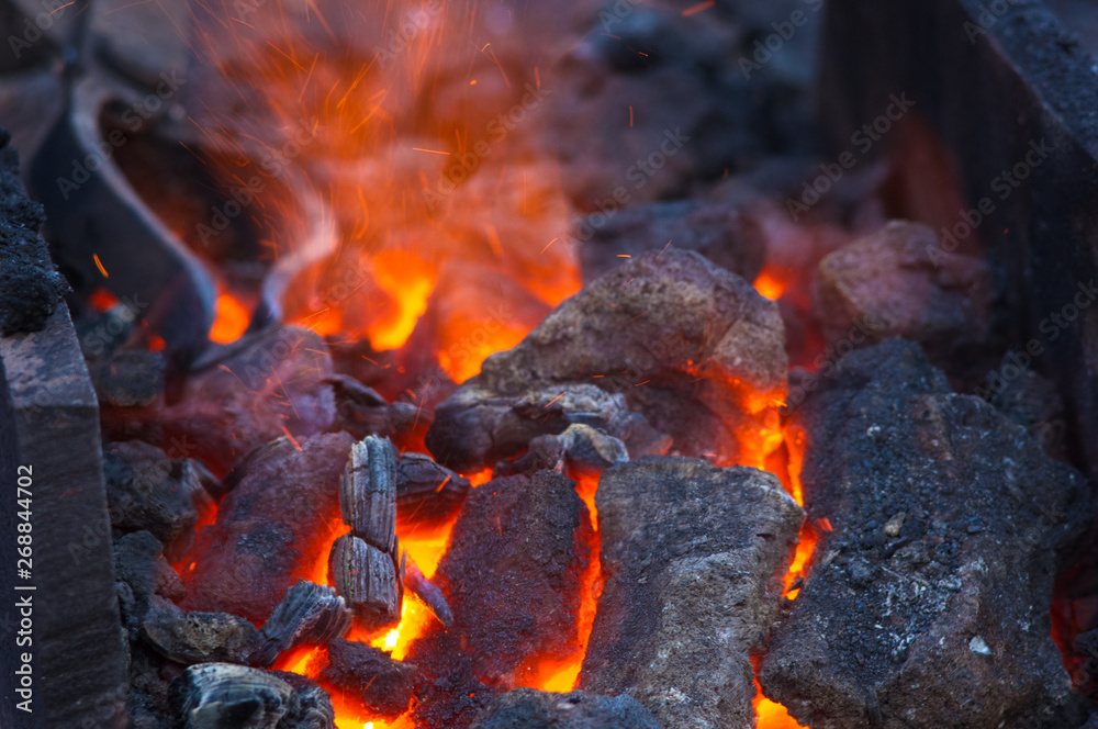 blacksmith furnace with burning coals, tools, and glowing hot metal workpieces blacksmith furnace with burning coals, tools, and glowing hot metal workpieces