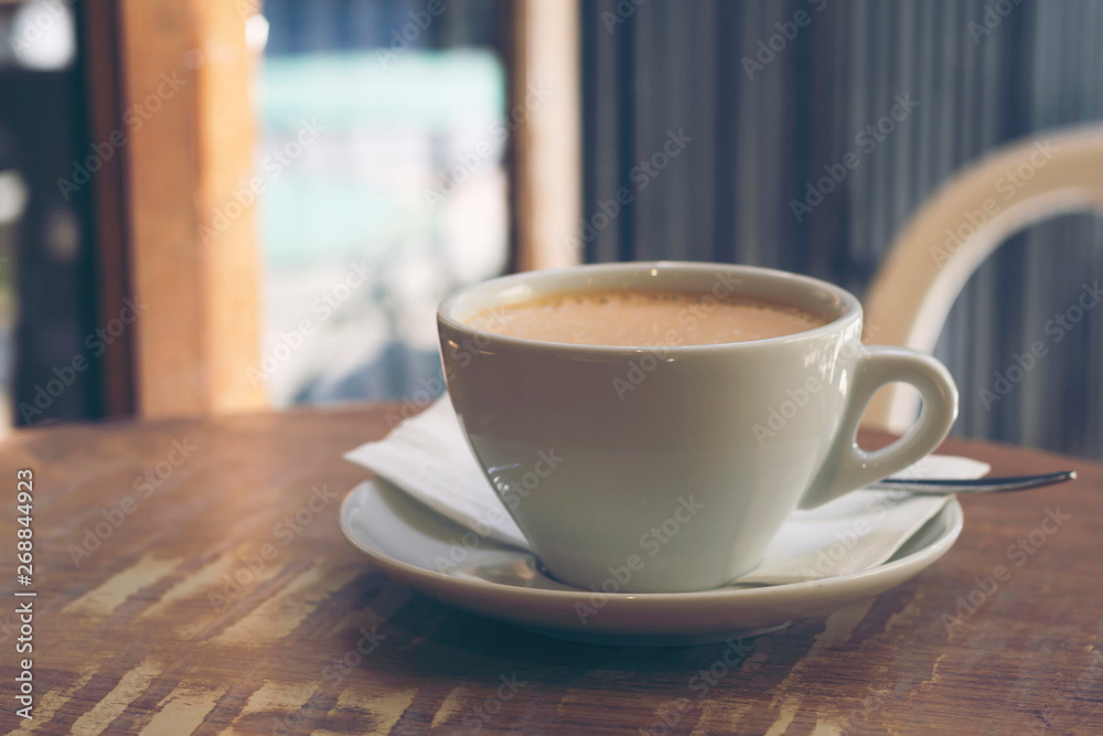 Cup of cappuccino coffee on the brown wooden table in street cafe, toned. Close-up, copy space Cup of cappuccino coffee on the brown wooden table in street cafe, toned. Close-up, copy space