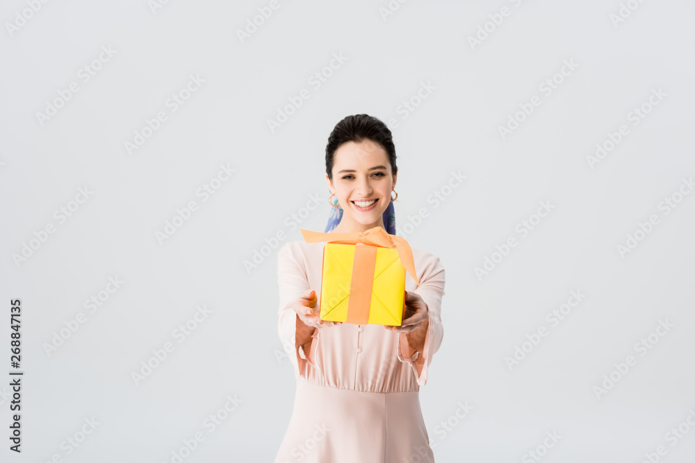 beautiful stylish young woman holding present and smiling isolated on grey beautiful stylish young woman holding present and smiling isolated on grey