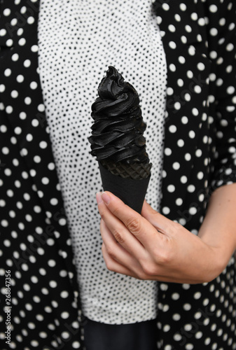 Woman holding black ice cream