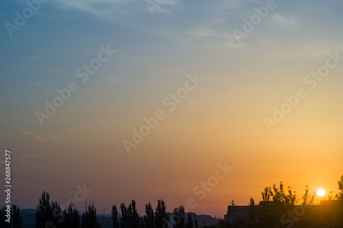 Landscape with dramatic light - beautiful golden sunset with saturated sky and clouds.