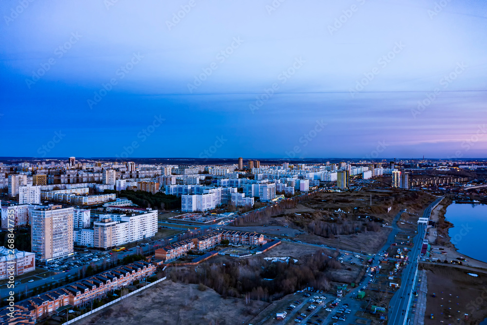 City landscape at sunset. Depicted: Bay, embankment, multi-storey and low-rise houses roads and cars. The view from the top. City landscape at sunset. Depicted: Bay, embankment, multi-storey and low-rise houses roads and cars. The view from the top.