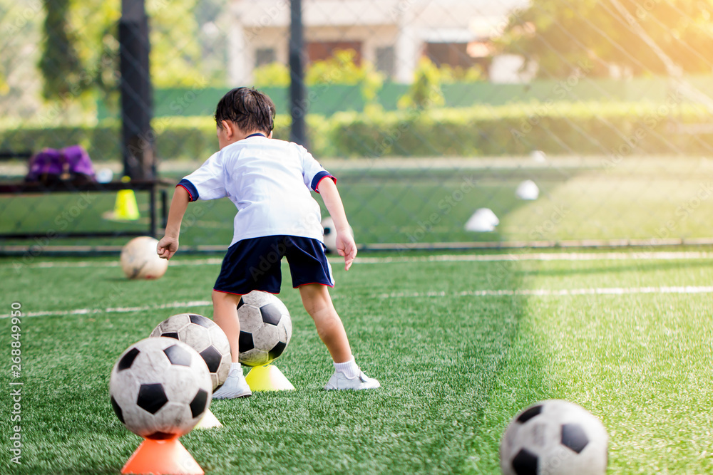 id soccer player is start training to shoot ball on marker cone to goal on artificial turf. id soccer player is start training to shoot ball on marker cone to goal on artificial turf.