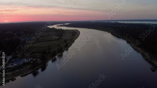Aerial top view fly over river Lielupe in Jurmala, Latvia Spring 2019 during sunrise with crimson violet and pink sky - Sun barely showing