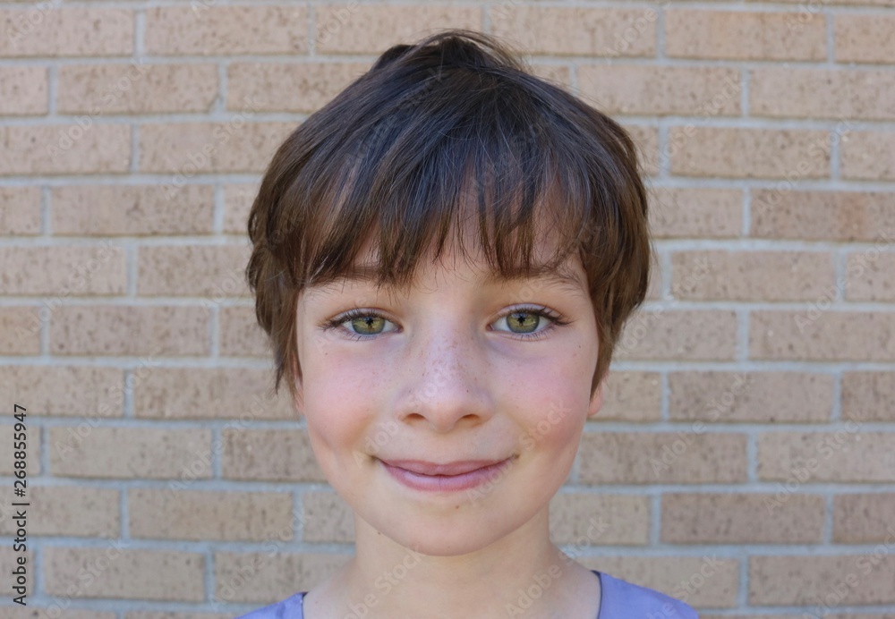 Face of young child with stunning hazel eyes, short brown pixie hair and dimples Face of young child with stunning hazel eyes, short brown pixie hair and dimples