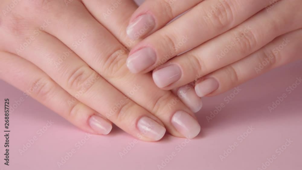 closeup woman hand on pink and other hand tpuches another.Ideal natural manicure closeup woman hand on pink and other hand tpuches another.Ideal natural manicure