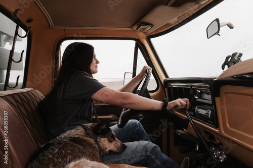 young woman driving stick shift in old pickup photo