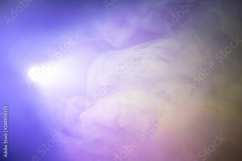 projector spotlight purple color , smoke abstract texture background . light beam screening and glowing for movie cinema and film multimedia production in studio , freeform swirl gas in the air .