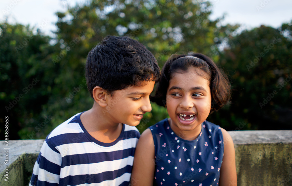 Young boy sharing a secret with his younger sister,having fun Stock
